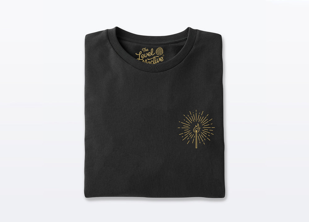Black Unisex T-shirt made with sustainable organic cotton. Small Front Chest design of a lit match printed in gold.