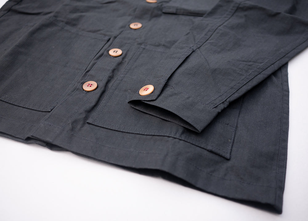 Black Unisex Overshirt handmade in Britain from weatherproof waxed organic cotton and sustainably sourced natural corozo nut buttons.