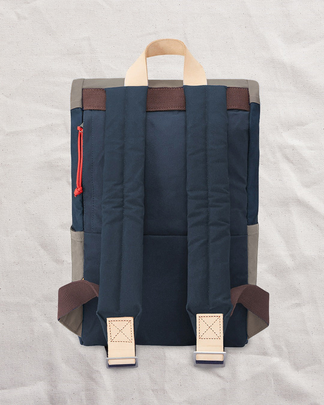 Back of the Navy & Stone roll top backpack with padded shoulder straps and natural leather tabs