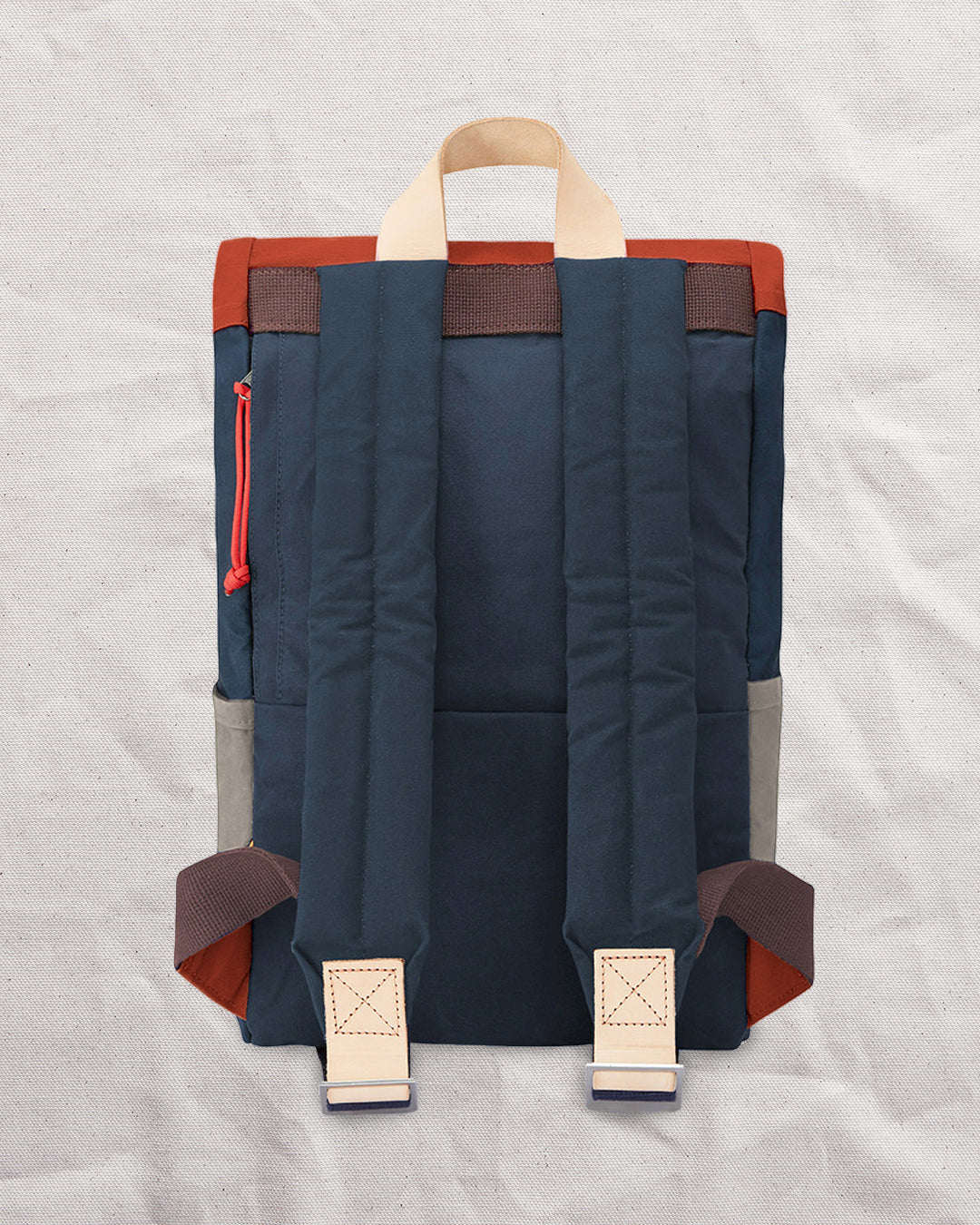 Back of the Wild One Navy roll top backpack with padded shoulder straps and natural leather tabs