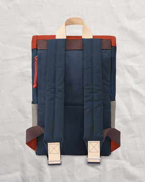 Back of the Wild One Navy roll top backpack with padded shoulder straps and natural leather tabs