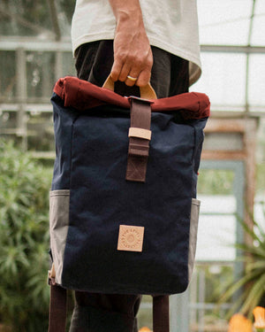Natural leather grab handle on the Wild One Navy roll top backpack with rust roll top