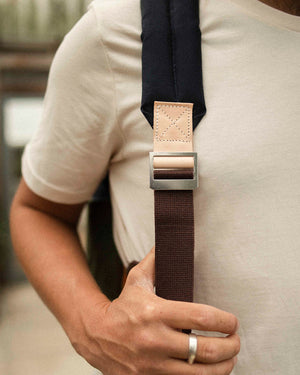 Padded shoulder strap with steel buckle on the Wild One Navy roll top backpack