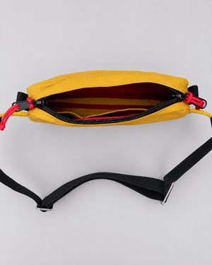 The Scout in Mustard open from above showing the red lining and black webbing strap