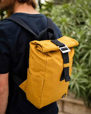 Close up of the Roll Top Mini in Mustard waxed cotton with black webbing