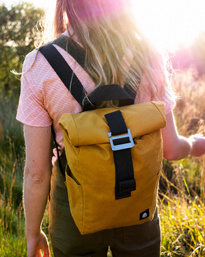 Roll Top Mini in Mustard worn in golden sunlight, black straps and steel buckle