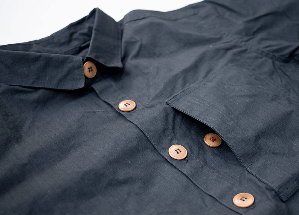 Black Unisex Overshirt handmade in Britain from weatherproof waxed organic cotton and sustainably sourced natural corozo nut buttons.
